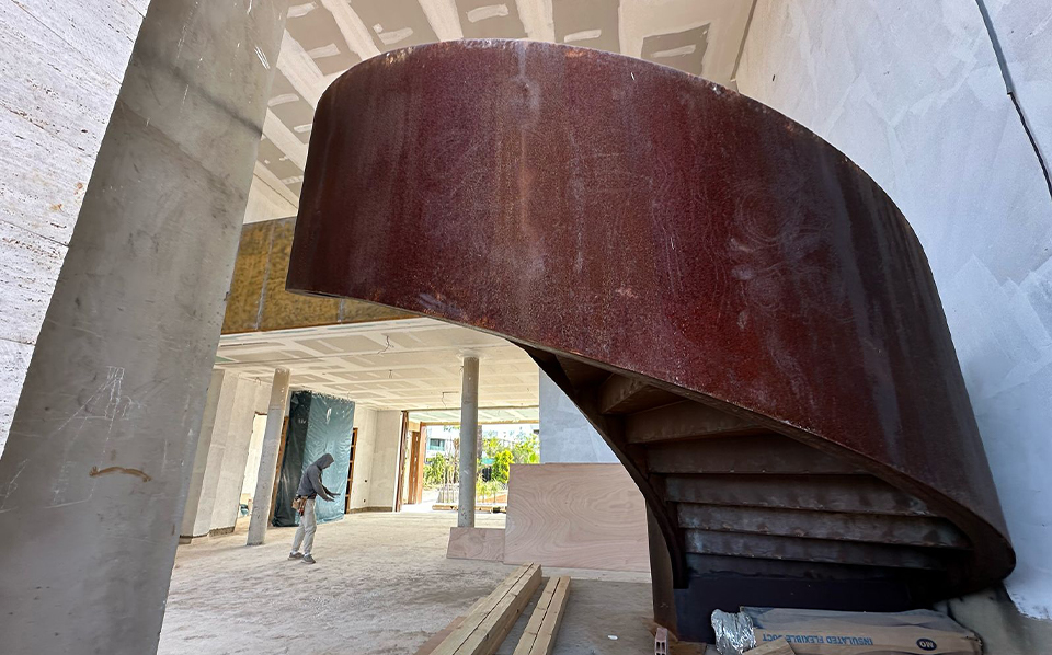 Escalier hélicoïdal en Acier Corten installé dans l’espace intérieur d’un bâtiment contemporain