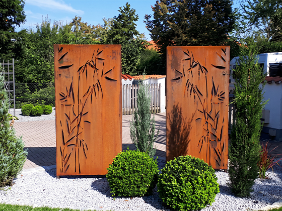Claustras décoratifs en acier Corten avec motifs de bambou découpés au laser dans un jardin