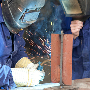Soudeur assemblant une structure en acier Corten dans un atelier de fabrication au Maroc