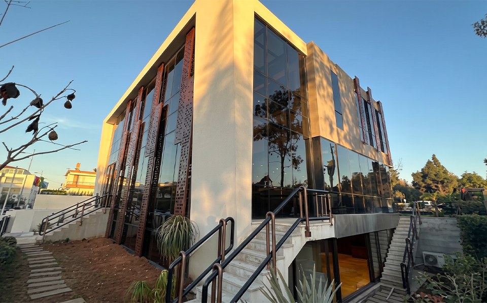 Panneaux verticaux perforés en Acier Corten installés sur la façade vitrée d’un bâtiment contemporain