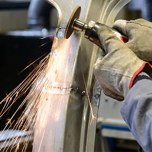 Meulage de précision d’une pièce en acier Corten sur mesure dans un atelier de fabrication