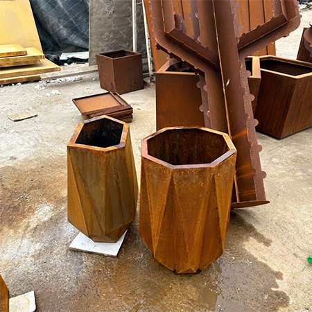 Jardinières polygonales fabriquées dans un Atelier acier Corten avec plusieurs éléments métalliques en préparation