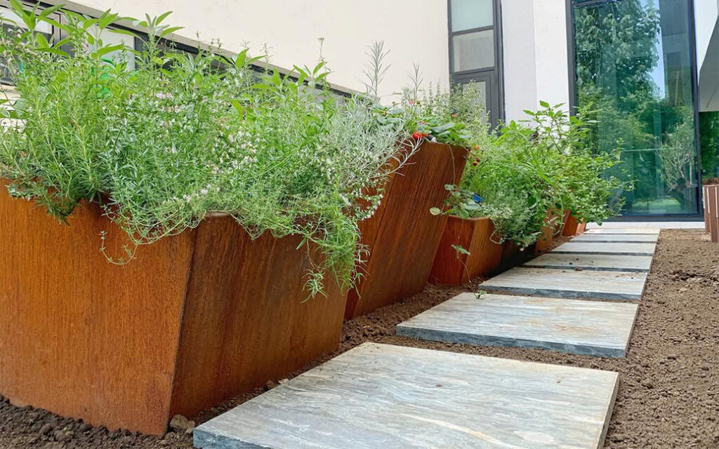 Fabrication acier Corten Maroc de jardinières et bacs sur mesure installés le long d’une allée moderne