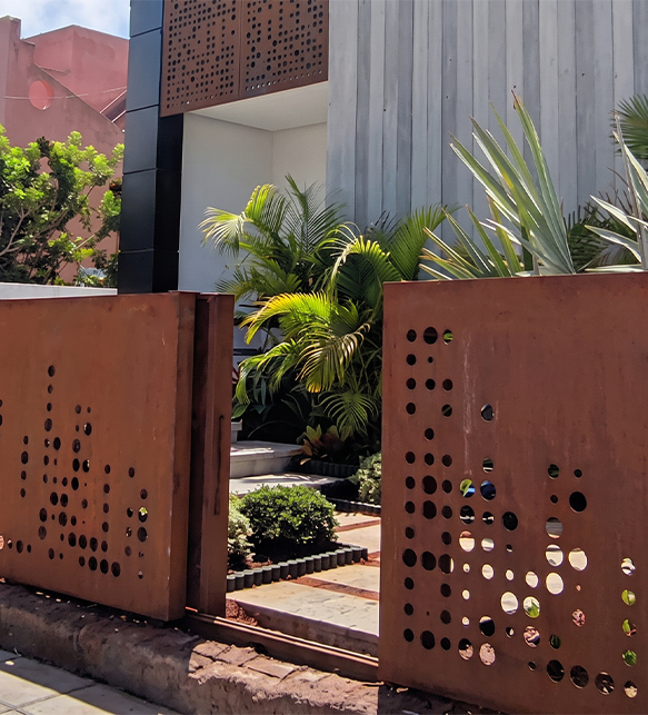 Fabrication acier Corten Maroc d’un portail perforé sur mesure installé à l’entrée d’un jardin contemporain
