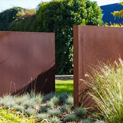 Fabrication Corten sur mesure de jardinières rectangulaires installées dans un jardin paysager contemporain